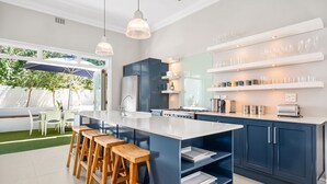 A modern kitchen with a large island, bar stools, and built-in appliances. - Bellevue House - Three Bedroom House, Sleeps 6 (Cape Town)