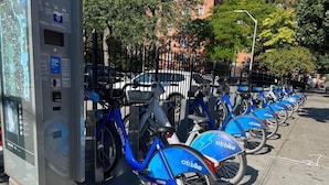 A row of Citi Bike rental stations with bicycles parked in front. - East Harlem Hostel (New York)