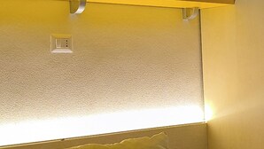 A bed with a yellow pillow, a textured wall, and two framed pictures above the bed. - Panoramic apartment with pool 2 - Liberato Puglia (Peschici)