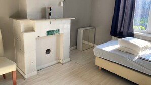 A bedroom with a bed, a bedside table, a chair, a small cabinet, and a window with curtains. - 8P 5B Business Stay StPhilipsland for Expats (Sint Philipsland)