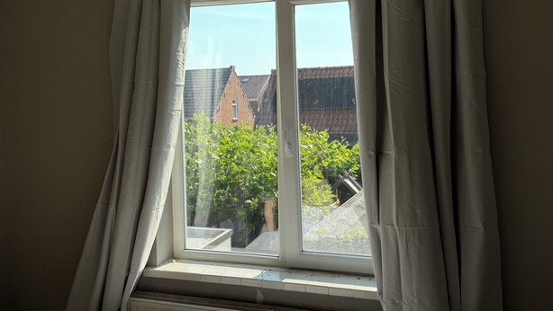 A room with a bed, a window with curtains, and a view of buildings outside. - 8P 5B Business Stay StPhilipsland for Expats (Sint Philipsland)