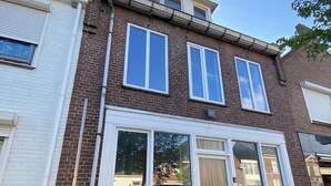 A two-story residential building with a brick facade, large windows, and a visible front door. - 8P 5B Business Stay StPhilipsland for Expats (Sint Philipsland)