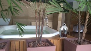 A spa area with a hot tub, wooden flooring, and potted plants. - Elegance and comfort for your vacation - apartment with 3 suites at Marine Resort. (Florianópolis)