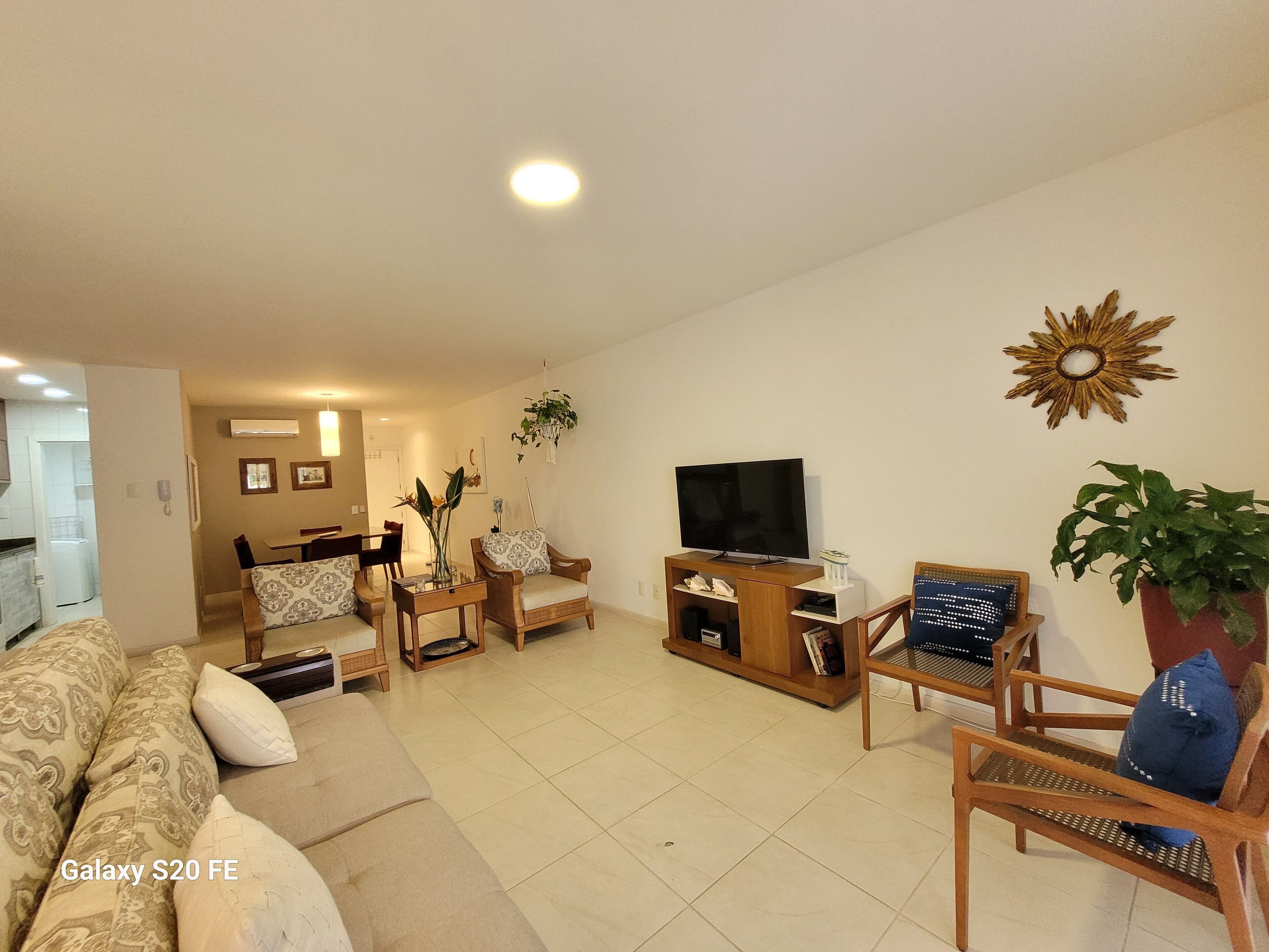 A living room with a sofa, chairs, a TV, and a dining area.