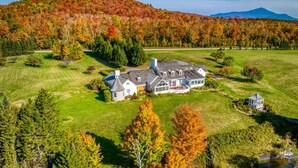 A large estate with a main house, a guest house, and a well-maintained lawn.