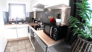 A modern kitchen with a built-in oven, microwave, and stainless steel sink.