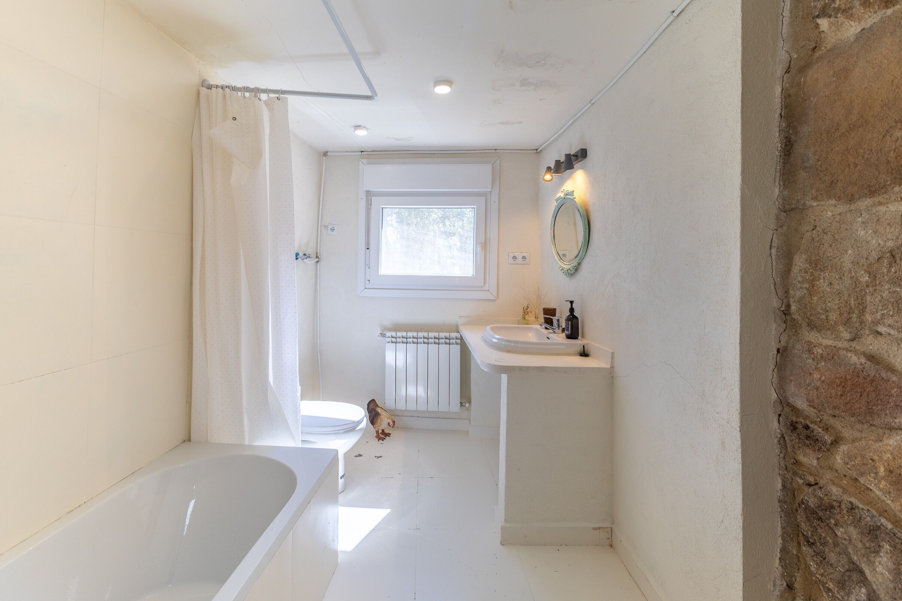 Un baño con bañera, lavabo, espejo y ventana.