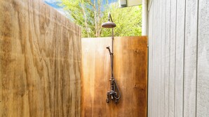 A wooden shower enclosure with a rain showerhead and hose. - Treetop Break - Waipu Cove Holiday Home (Waipu Cove)