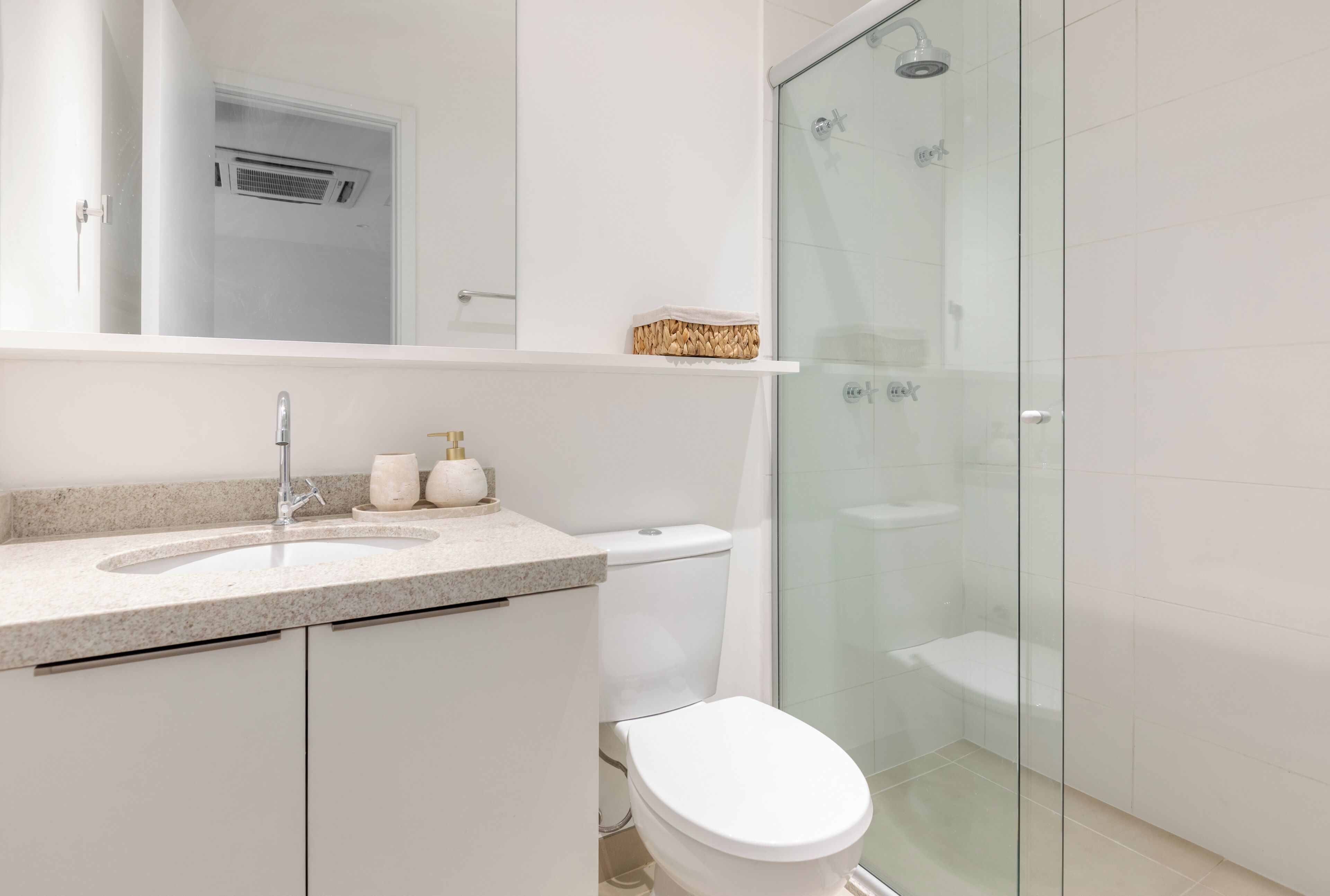Une salle de bain moderne avec une douche à parois de verre, un lavabo blanc et des toilettes.