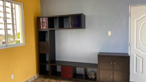 Huone, jossa on sisäänrakennettu penkki, pieni kaappi ja ovi.