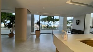 Un interior espacioso y moderno con amplias ventanas que ofrecen vistas a árboles y un paisaje lejano.