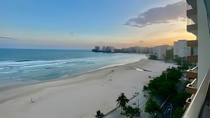 Una playa con vista al océano y un horizonte urbano a lo lejos.