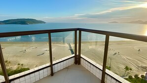 Uma varanda com vista para a praia e o mar.