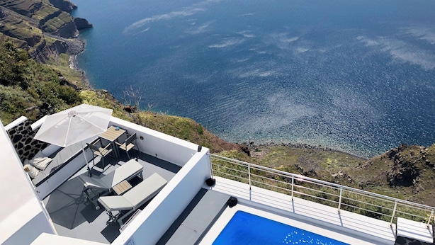 En tagpool med udsigt til havet og klipper.