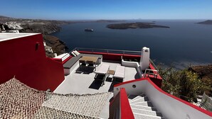 En trappe fører op til en terrasse med udsigt over havet og øerne.