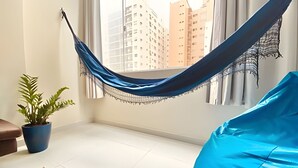 A room with a hammock, a blue bean bag, and a potted plant. - SHB - Beachfront in Pitangueira, Guaruja (Guarujá)