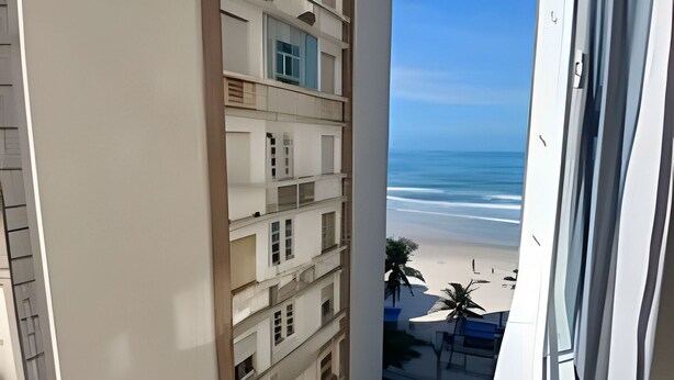 A high-rise building with multiple balconies overlooking a beach. - SHB - Beachfront in Pitangueira, Guaruja (Guarujá)