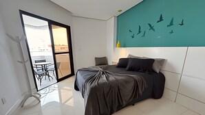 Una camera da letto moderna con un letto, un balcone con tavolo e sedie, e un murale con uccelli al muro.