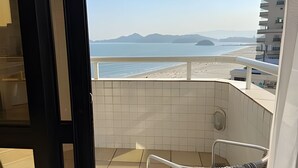 Uma varanda com vista para a praia e montanhas.
