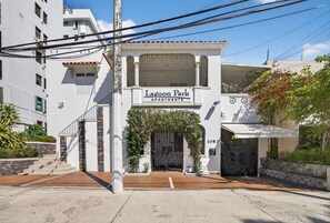 Un immeuble avec une enseigne indiquant « Lagoon Park Apartments » et une entrée fermée par un portail.