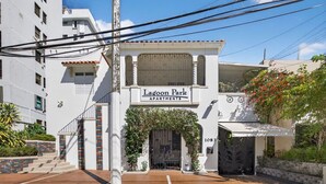 Ein Gebäude namens Lagoon Park Apartments mit einem gesicherten Eingang, einer Treppe und einem Ziegelweg, der zur Tür führt.