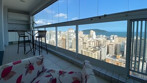 Ein Balkon mit Blick auf die Stadt, ein kleiner Tisch, zwei Stühle und eine Sitzecke.