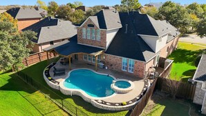 A large house with a swimming pool, a covered patio, and a fenced yard. - 6BD Luxury Retreat w Backyard & Access Golf Course (Frisco)