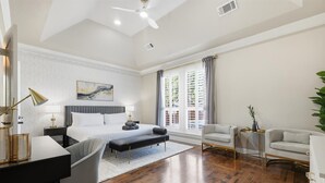 A modern bedroom with a large bed, bedside tables, a desk, and a chair. - 6BD Luxury Retreat w Backyard & Access Golf Course (Frisco)