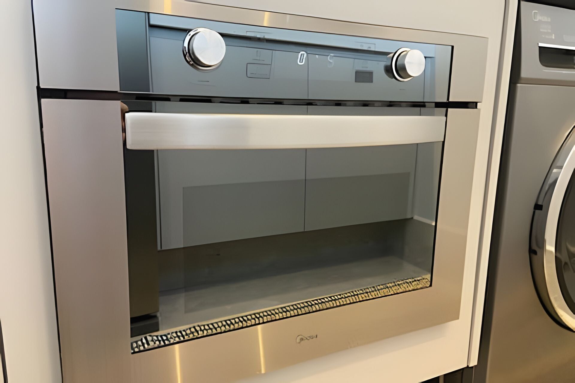 Ein Edelstahlbackofen mit zwei Drehreglern und einer Glastür.