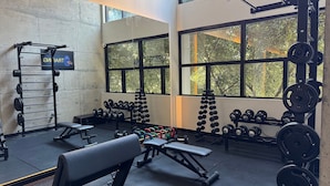 A gym with weightlifting equipment, benches, and dumbbells. - Studio near Sirio Libanes and Frei Caneca (São Paulo)