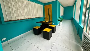 Un intérieur moderne avec des murs de couleur turquoise, une table noire et jaune, et une plante en pot.