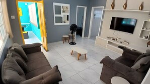 Un salon comprenant un canapé, un téléviseur et une petite table.