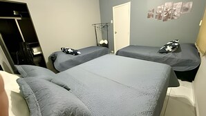 Une chambre avec deux lits, une armoire et un miroir.