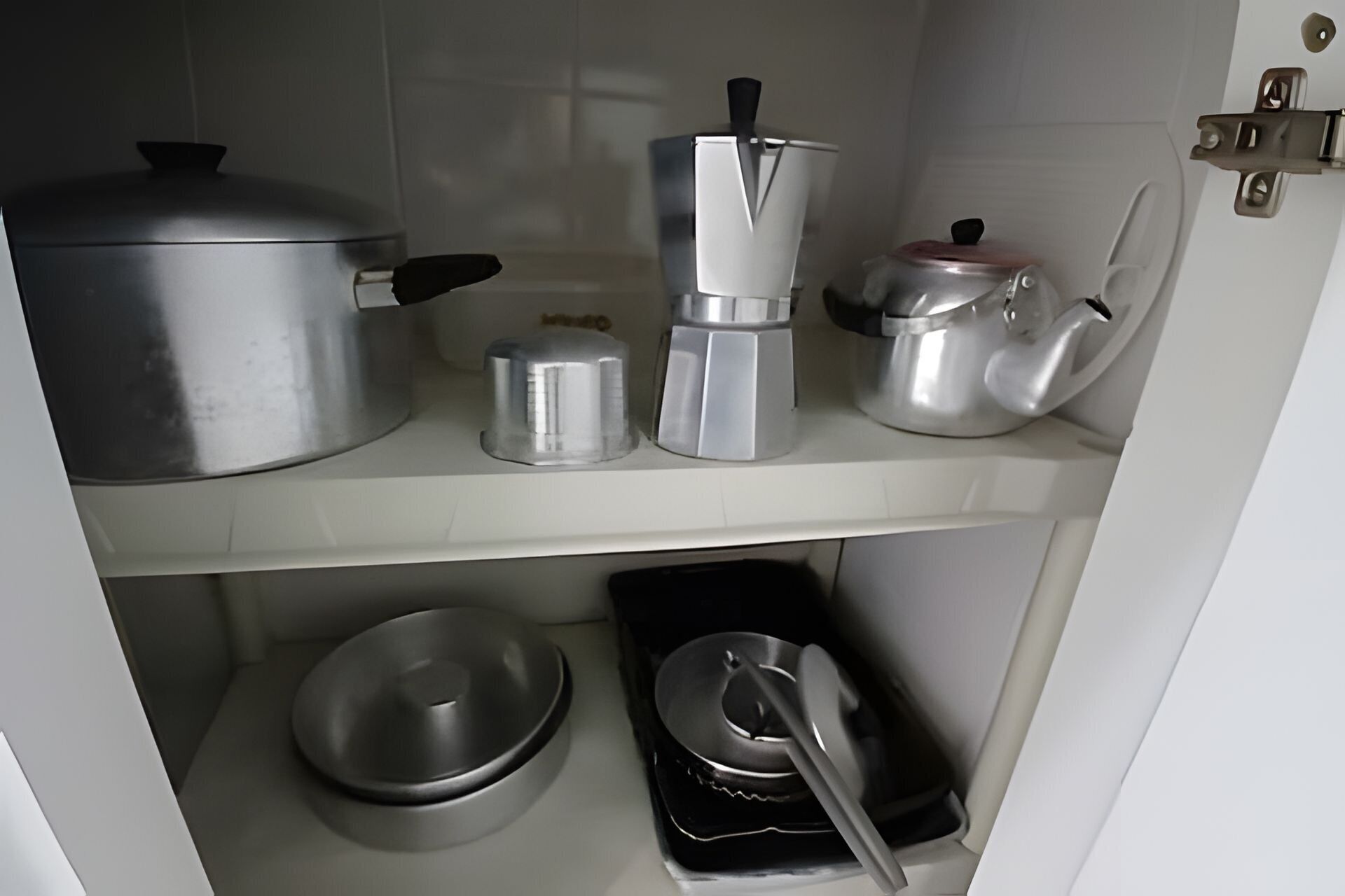 Une cuisine équipée d’ustensiles de cuisine en acier inoxydable, notamment une casserole, une cafetière et une bouilloire.