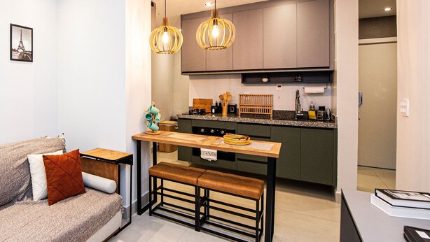 A modern kitchen with a central island, pendant lighting, and a dining bench. - SHB • Praiamar Shopping | Beach Just Steps Away (Santos)