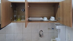 A kitchen with a wooden cabinet, a sink, and a toilet. - SHB - Maritime Comfort: Studio with Sea View (Santos)