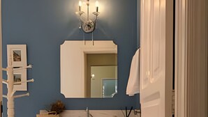 Une salle de bain avec un mur bleu, un meuble-lavabo blanc et un miroir.