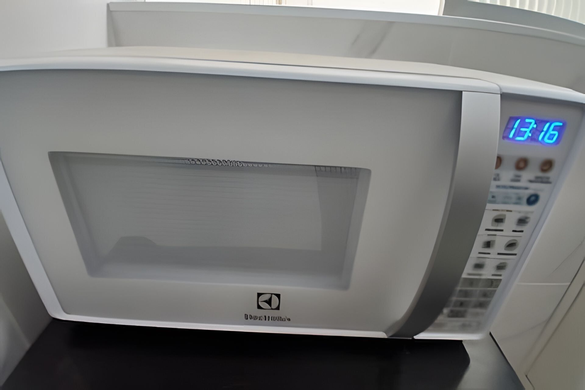 A microwave oven with a digital display showing 13:16.