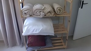 A wooden shelf unit with towels and a folded blanket. - SHB - Happy family: Fast Wi-Fi 1 minute from the beach (São Vicente)