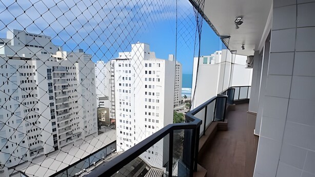 Ein Hochhaus mit modernem architektonischen Design, mit Glasfassade und einem Metallzaun.