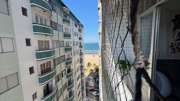 Un edificio alto con varios balcones que dan a una playa.