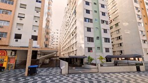 Un immeuble résidentiel à plusieurs étages, doté de balcons, d’une entrée sécurisée et d’un revêtement de sol à motifs.
