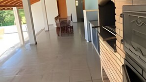 Eine Terrasse im Freien mit Kamin aus Ziegelsteinen und Holzbalkendecke.