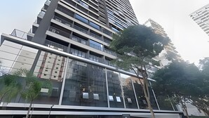 Un moderno grattacielo con facciata in vetro e numerosi balconi.