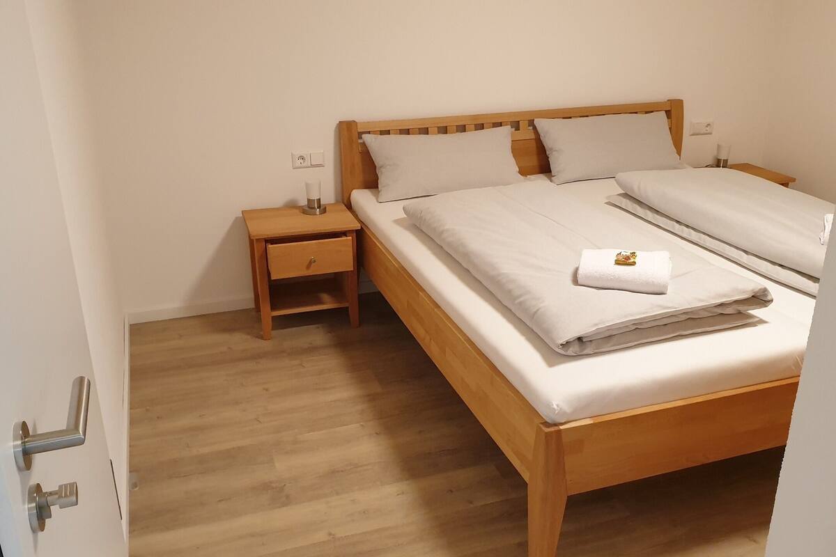 Ein Schlafzimmer mit einem hölzernen Bett, einem Nachttisch und Holzboden.