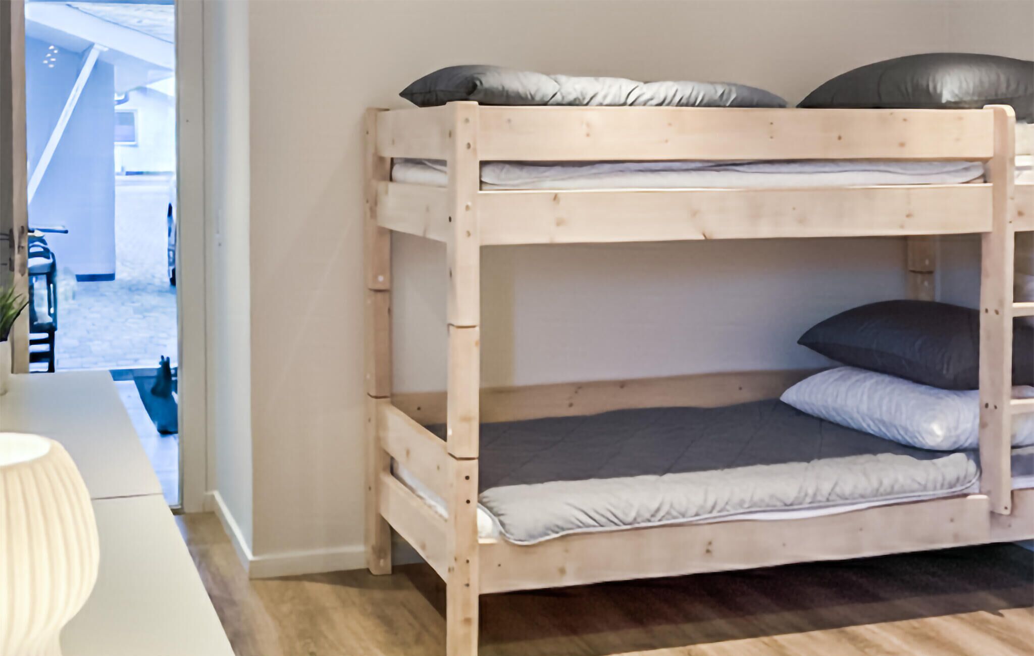 Ein Etagenbett mit zwei Schlafstellen, jeweils mit Kissen und Matratze.