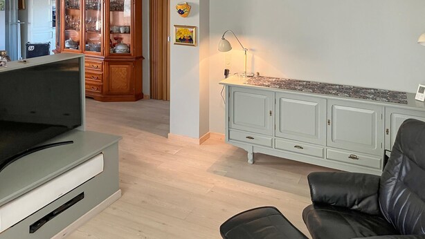 A living room with a TV, a cabinet, a sofa, and a lamp. - 3 bedroom cozy home in Bøvlingbjerg (Bøvlingbjerg)