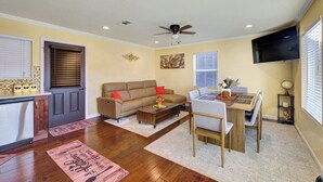 Una sala de estar con sofá, mesa de centro y mesa de comedor.