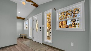 A hallway with wooden flooring, white doors, and windows with autumn foliage views. - The Lakeview Lookout - Gorgeous Lake Views! (Lexington)