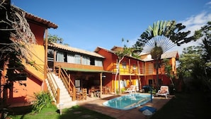A two-story building with a swimming pool, outdoor seating, and a staircase leading to the upper level. - Mandacaru Pousada (Porto Seguro)